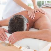 Man receiving back massage in spa centre